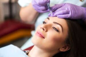 A woman receiving a Botox injection from a doctor, ensuring a Botox refresh to maintain her smooth, youthful appearance